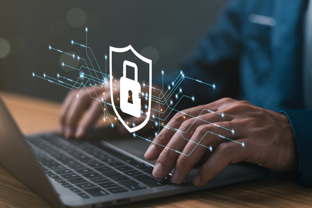 Hands on a laptop with an image of a lock and connecting lines overtop of it.